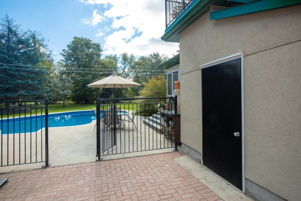 Black aluminum fence around a backyard pool